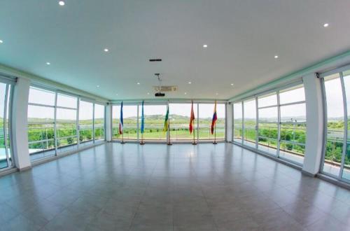 a large room with large windows and a view of the ocean at Hotel Campestre El Cisne in Barranquilla