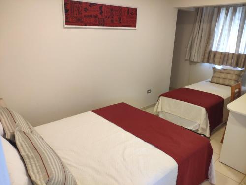 a bedroom with two beds and a picture on the wall at Hotel Maea Hare Repa in Hanga Roa