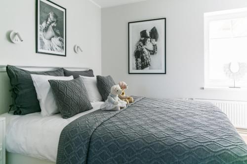 a teddy bear sitting on a bed in a bedroom at Viigi Villa in Haapsalu