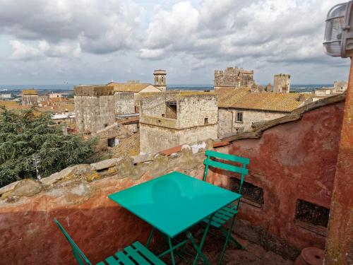 a green table and chairs sitting on top of a building at L’Arrocco - La Torre col Mare sul Tetto in Tarquinia