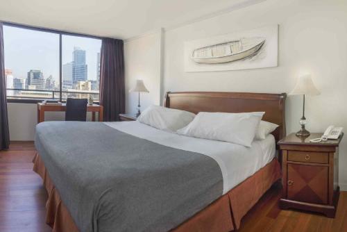 a bedroom with a bed with a view of a city at Santa Magdalena Apartments in Santiago