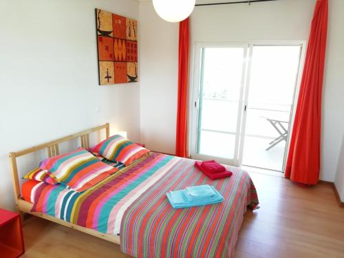 a bedroom with a bed and a large window at Casa Luminosa in Carrapateira
