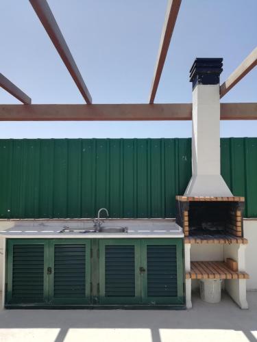 a green building with a sink and a pole at Casa Luminosa in Carrapateira