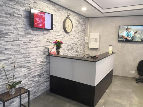 a cashier counter in a room with a brick wall at Hôtel Moderne in Saint-Denis