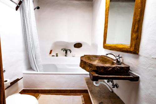 a bathroom with a sink and a bath tub at Oliveira Surf House Ericeira in Santo Isidoro
