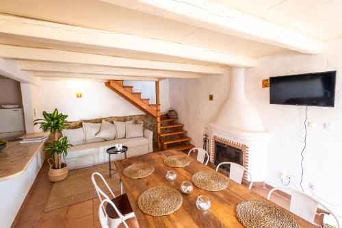 a living room with a wooden table and a fireplace at Oliveira Surf House Ericeira in Santo Isidoro