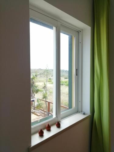 a window with vases sitting on a window sill at Casa Luminosa in Carrapateira