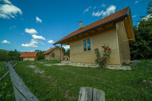 a wooden house with a fence in front of it at Holiday Homes Eko Klanac in Rakovica