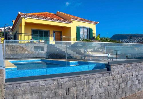 a villa with a swimming pool in front of a house at Villa Sunrise View by Homie in Santa Cruz