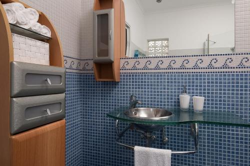 a bathroom with a sink and a blue tiled wall at Villa Sunrise View by Homie in Santa Cruz