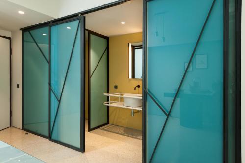 a bathroom with glass doors and a sink at Arcade Project Hi-end Apartments in Athens