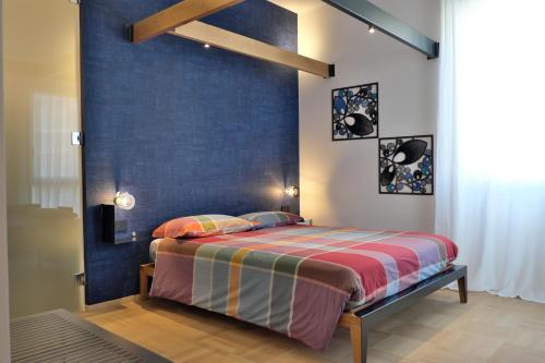a bedroom with a bed with a blue wall at INVENTO bnb unconventional maison in Civitanova Marche