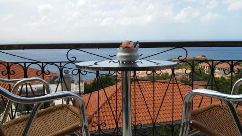 a table on a balcony with a view of the ocean at Maria & Kiki 1 Studios in Mithymna