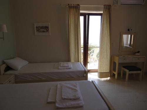 a hotel room with two beds and a window at Maria & Kiki 1 Studios in Mithymna