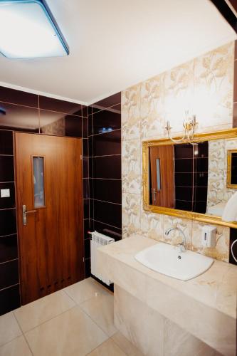a bathroom with a sink and a mirror at Hotel Korczowa in Młyny