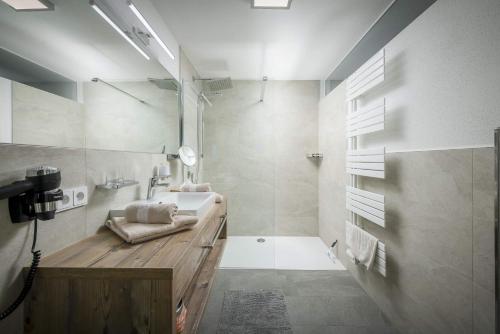 a white bathroom with a sink and a mirror at Kaiserwinkl Apartments Daxer in Walchsee