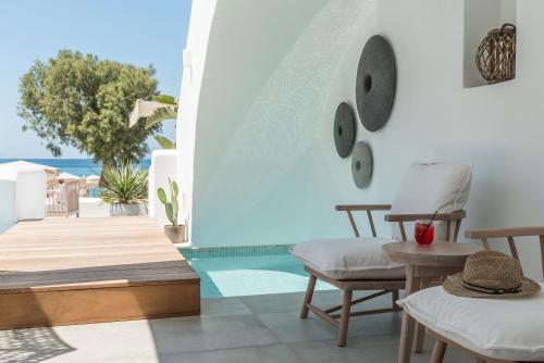 a room with chairs and a table and a view of the ocean at Virtu Suites in Agios Prokopios