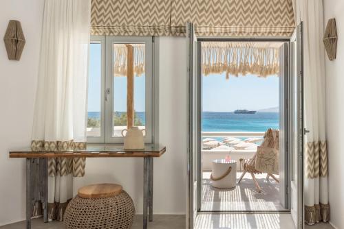 a room with a sliding glass door with a view of the ocean at Virtu Suites in Agios Prokopios