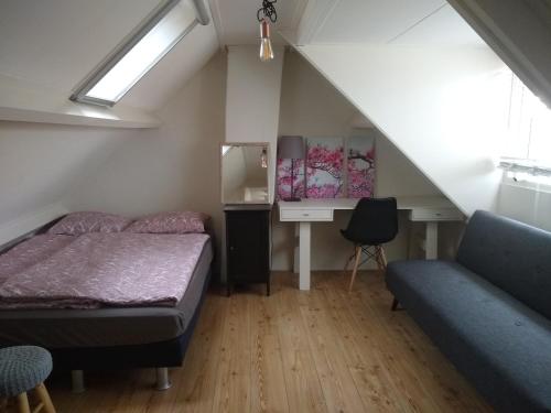 Dormitorio con cama y escritorio en el ático en AwayHome Zwolle, en Zwolle