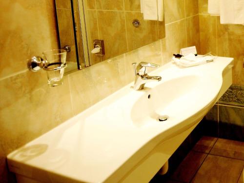 a bathroom with a white sink and a mirror at Marygreen Manor in Brentwood