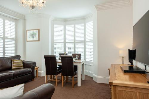 a living room with a table and a couch at Carlton 2 a large modern Keswick appt with parking in Keswick