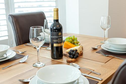 a bottle of wine sitting on top of a wooden table at Carlton 2 a large modern Keswick appt with parking in Keswick