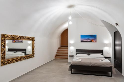 a bedroom with two beds and a mirror at Casa Vacanze Al Duomo Ibla in Ragusa