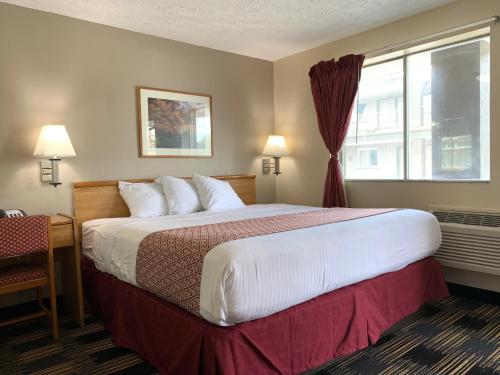 Habitación de hotel con cama grande y ventana en Sandusky Inn en Sandusky