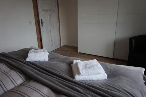two white towels sitting on top of a bed at Ferienhaus Hundertmorgenfeld 33 in Wernigerode