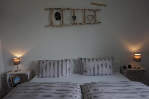 a bed with striped pillows in a bedroom with two lamps at Ferienhaus Hundertmorgenfeld 33 in Wernigerode