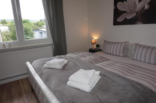 a bedroom with two towels on a bed with a window at Ferienhaus Hundertmorgenfeld 33 in Wernigerode