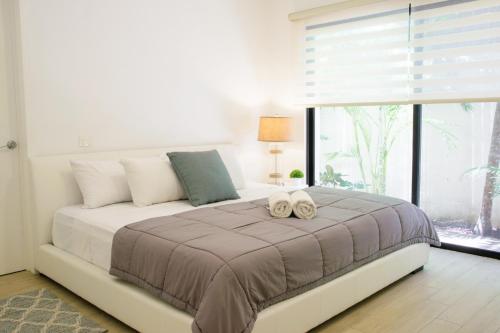 a bedroom with a large bed with two towels on it at Che Suites Tulum in Tulum