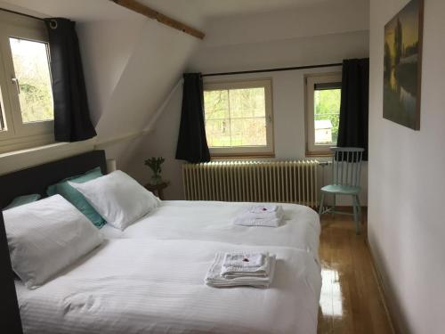 - une chambre avec un lit et des serviettes dans l'établissement B&B de Druif, à Breda