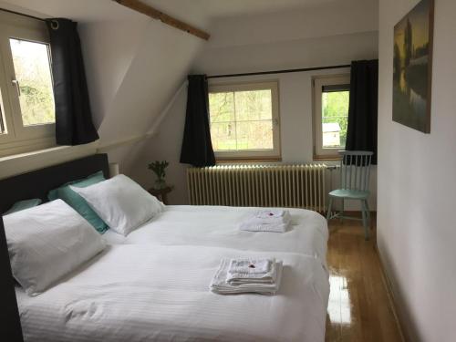 a bedroom with a bed with towels on it at B&B de Druif in Breda