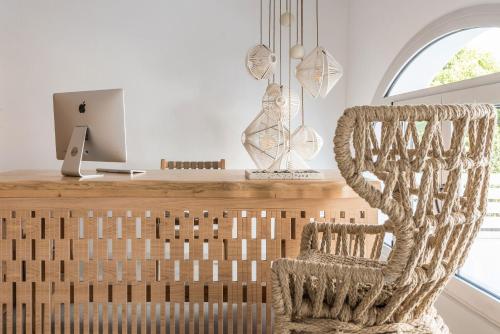 a chair in front of a desk with a computer at Virtu Suites in Agios Prokopios