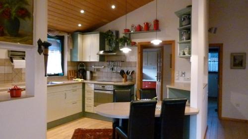 eine Küche mit einem Tisch und einigen Stühlen in der Unterkunft Ferienhaus zwischen Wald und See in Möhnesee