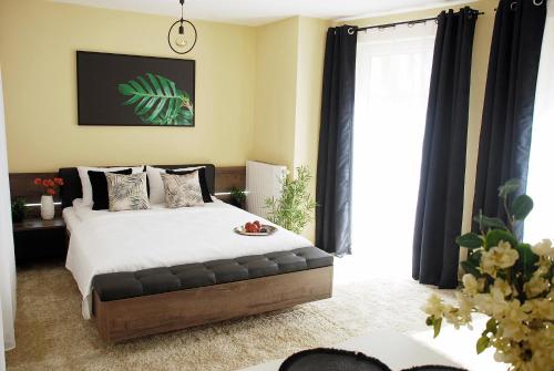 a bedroom with a large bed with black curtains at Central Point in Zielona Góra