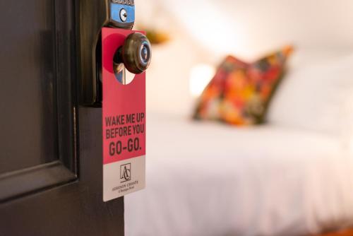 a door knob with a sign on it next to a bed at Addison Choate in Rockport