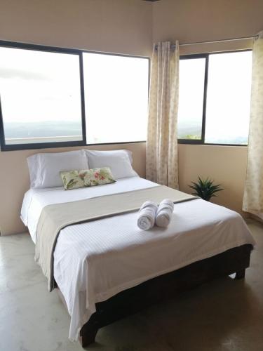 a bedroom with a large bed with two towels on it at Casa Linda Vista in Caño Seco