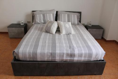 uma cama com duas almofadas em cima em Appartamento Galileo em Veglie