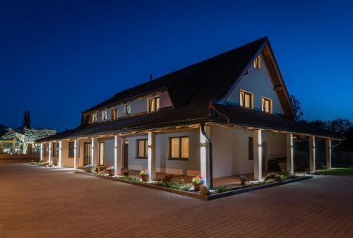 a large house with a black roof at night at Na Verande apartments Jasna in Liptovský Mikuláš