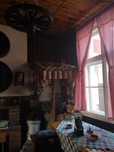 a room with a table and a window and a table with a tablecloth at Etno Konak Angela in Kalna