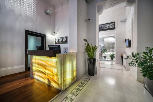 a lobby with a gold counter in the middle of a room at Opera Garden Hotel & Apartments in Budapest