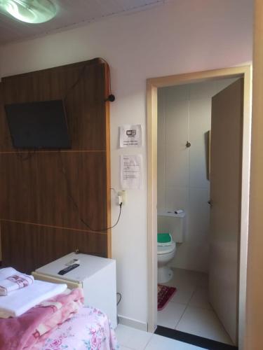 a room with a bed and a bathroom with a toilet at Pousada Vale das Águas foz in Foz do Iguaçu