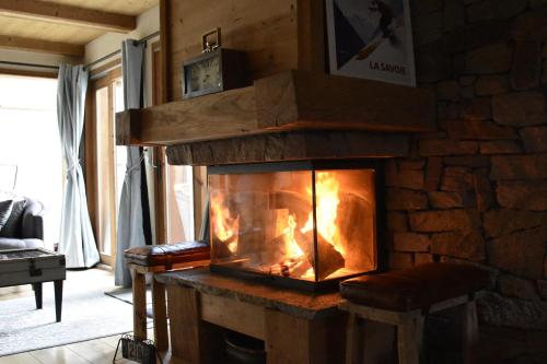 a fireplace in a room with a stone wall at Chalet Beaufort in Saint-Martin-de-Belleville