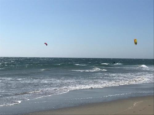 two people flying kites in the ocean on the beach at Vistazul in Vichayito