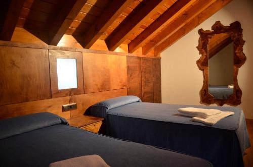 2 camas en una habitación con espejo en Apartamentos Spa Cantabria Infinita, en Cillorigo de Liébana