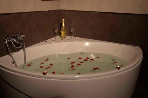 a bath tub with wine glasses and a bottle of champagne at Apartamentos Spa Cantabria Infinita in Cillorigo de Liebana