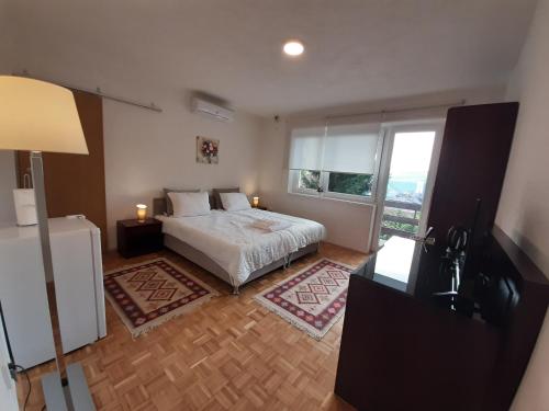 - une chambre avec un lit et une grande fenêtre dans l'établissement Guesthouse Hill, à Sarajevo