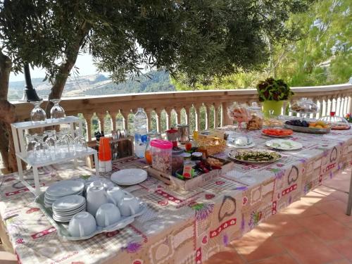 een tafel met eten en borden en flessen erop bij Masseria Stamato in Amendolara
